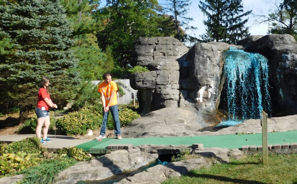 playing mini golf by waterfall