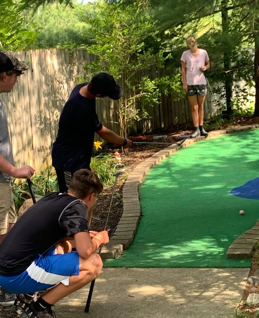 boys putting while girl looks on